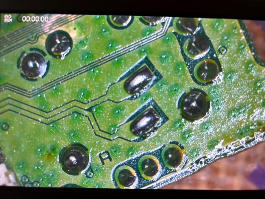 Microscope view of surface-mount solder joints on a green board