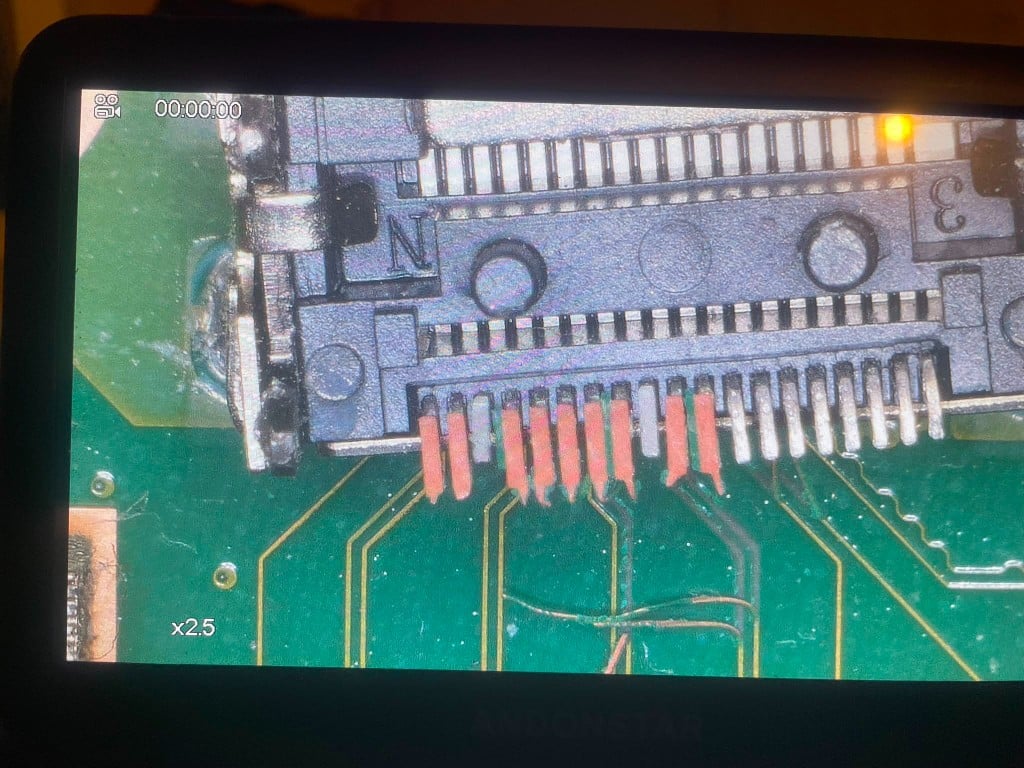 Microscope view of repaired FPC connector with jumper wires