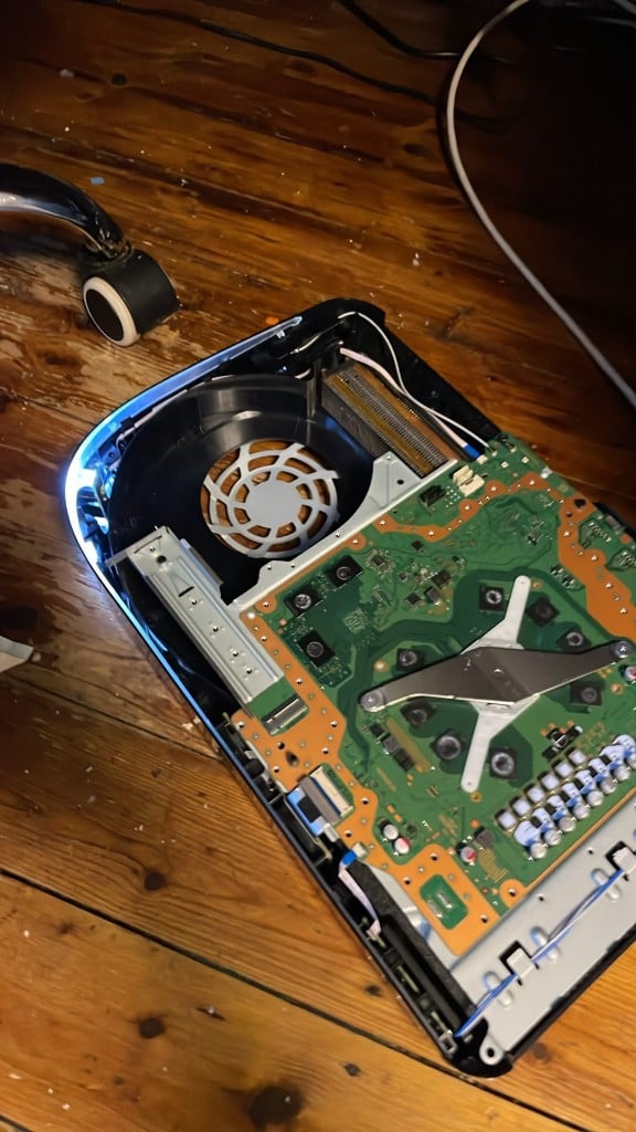 Opened PlayStation 5 showing motherboard, fan and LED strip