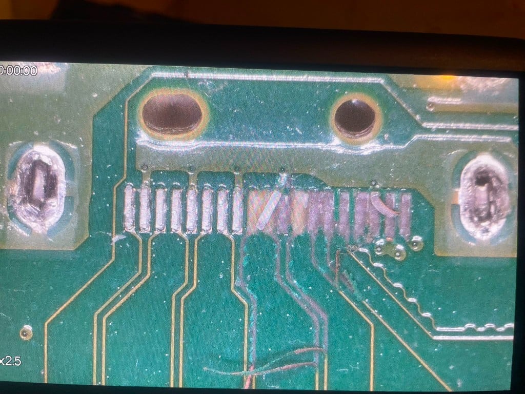 Microscope view of pad damage repaired with copper jumper wires